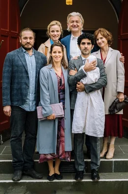 ARD Degeto FAMILIE IST EIN FEST - TAUFALARM, am Samstag (28.06.25) um 15:30 Uhr im ERSTEN. Kaum ist der kleine Linus auf der Welt, sieht sich das deutsch-iranische Rheinl&auml;nderpaar Viola (Amelie Kiefer, vorne ) und Faraz (Reza Brojerdi, vorne re.) mit kulturellen Unterschieden konfrontiert - Taufe oder Beschneidung! Hinten: Max (Denis Schmidt), Frederike Helmrich (Isabel Thierauch), Holger Helmrich (Dominic Raacke) und Beatrice Helmrich (Victoria Trauttmansdorff).