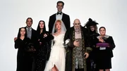 Die d&uuml;stere Familie Addams feiert die Liebe zwischen Onkel Fester (Christopher Lloyd, 3.v.r.) und Debbie (Joan Cusack, M. vorne). Wednesday (Christina Ricci, l.), das Ehepaar Morticia (Anjelica Huston, 3.v.l.) und Gomez Addams (Ra&uacute;l Juli&aacute;, 2.v.l.), Lurch (Carel Struycken, M. hinten), Gro&szlig;mutter (Judith Malina, 2.v.r.) und Pugsley (Jimmy Workman, l.) trauen der geheimnisvollen Debbie jedoch nicht.