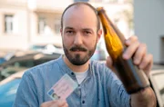 exactly-Reporter Jonas Armbruster mit Führerschein und Bierflasche