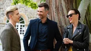 Evas Geburtstagsfeier ist in vollem Gange: Paul (Lennart Betzgen, l.) und Livia (Livia Matthes) machen ihrer Mutter zu Liebe gute Miene zu der scheinheiligen Familienfeier. Oli (Jo Weil) lässt sich von Pauls guter Laune anstecken.