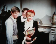 Curtis Norton (Ned Beatty, M.) hat sein Haus auf Hochglanz gebracht, um Anne Harris (Ivy Jones, r.), der er einen Heiratsantrag gemacht hat, zu beeindrucken. John-Boy Walton (Richard Thomas, l.) hat Anne vom Bus abgeholt und zu Curtis begleitet.