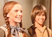 Laura (Melissa Gilbert, l.) freut sich sehr, dass ihr Freund Andrew (Patrick Laborteaux, r.) und seine Eltern nun auch in der Stadt angekommen sind.