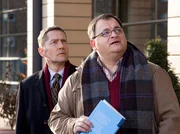 Hans-Peter Brenner (Michael Trischan, rechts) hat eine urologische Fachfrage an Dr. Rolf Kaminski (Udo Schenk) und fängt diesen vor der Klinik ab. Doch Kaminski entdeckt auf dem Klinikdach Emil Lerchfeld, der ziemlich nah am Rand steht.