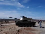 A series director on the phone next to a tank.