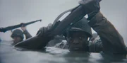 Der Gefreite Henry Parham (gespielt von Ishmel Bridgeman) watet am Omaha Beach in einer Szene einer historischen Nachstellung des Zweiten Weltkriegs f&uuml;r "Erased: WW2's Heroes of Color". Parham diente mit dem 320th Barrage Balloon Battalion am D-Day.