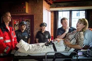 Dr. Haase (Fabian Harloff, 2.v.r.) untersucht Ingrid Ruhland (Sabine Kaack, r.), die bei dem Überfall auf ihre Bar mit einem Baseballschläger verletzt wurde. Claudia (Janette Rauch, M.) und Tarik (Serhat Cokgezen 2.v.l.) warten mit ihrer Befragung. Dr. Haase (Fabian Harloff, 2.v.r.) untersucht Ingrid Ruhland (Sabine Kaack, r.), die bei dem Überfall auf ihre Bar mit einem Baseballschläger verletzt wurde. Claudia (Janette Rauch, M.) und Tarik (Serhat Cokgezen 2.v.l.) warten mit ihrer Befragung.