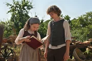 Rose (Alma von Aulock) und Heinrich (Leo Alonso-Kallscheuer) schauen in das gerade gefundene Märchenbuch. Auf der ersten Seite steht: „Dieses Buch gehört den Kindern der Welt“.