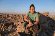 Albert Lin posiert für ein Porträt auf einem Felsen in der Wüste, während er eine Expedition tief in den Oman leitet, um nach Hinweisen zu suchen und das wahre Ausmaß und die Raffinesse einer verlorenen Wüstengesellschaft zu entdecken, die die größten Zivilisationen dieser Zeit hervorgebracht hat.