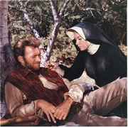 Nach einem Indianerangriff ist Hogan (Clint Eastwood, l.) schwer verletzt. Sara (Shirley MacLaine, r.) versucht, den Pfeil zu entfernen.