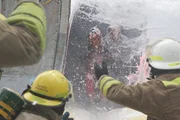 Feuerwehrleute rutschen aus dem Flugzeug.