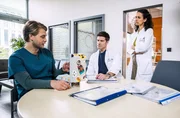 Dr. Mikko Rantala (Luan Gummich, l.) hat für die jungen Ärzte ein Medizin Quiz bereitgestellt und testet die Fragen an Dr. Ben Ahlbeck (Philipp Danne, m.) und Dr. Leyla Sherbaz (Sanam Afrashteh, r.). Wie gut sitzt das medizinische Wissen bei den beiden Oberärzten?
