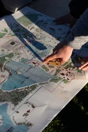 Eine Person zeigt einen Ort auf der Karte