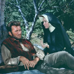 Hogan (Clint Eastwood, l.) lernt die Nonne Sara (Shirley MacLaine, r.) kennen. Beide sp&uuml;ren eine gegenseitige Verbundenheit. Hogan wei&szlig; Saras Geheimnis &uuml;ber ihre eigentliche Berufung nicht ...