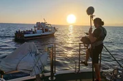 Tontechniker und ein Partyboot im Hintergrund auf Ibiza, Balearische Inseln. Spanien. (National Geographic/Jose Antonio Gavilán Tobal)