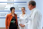 Britta (Jelena Mitschke, M.) gerät mit Prof. Seidinger (Herbert Trattnigg, r.) aneinander. Nach Brittas Meinung muss Arianes (Alexandra Horn, l.) Hand dringend operiert werden. Ihr Chef hält das allerdings für unnötig.