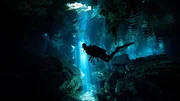 Scuba diver inside cenote with light stream from sun. Scuba diver inside cenote with light stream from sun.