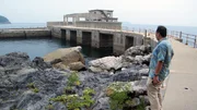 Tosh Minohara regarde vers le port, d'o&ugrave; partaient les Kaiten, die Unterseeboote der japanischen Armee.