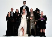 Die d&uuml;stere Familie Addams feiert die Liebe zwischen Onkel Fester (Christopher Lloyd, 3.v.r.) und Debbie (Joan Cusack, M. vorne). Wednesday (Christina Ricci, l.), das Ehepaar Morticia (Anjelica Huston, 3.v.l.) und Gomez Addams (Ra&uacute;l Juli&aacute;, 2.v.l.), Lurch (Carel Struycken, M. hinten), Gro&szlig;mutter (Judith Malina, 2.v.r.) und Pugsley (Jimmy Workman, l.) trauen der geheimnisvollen Debbie jedoch nicht.