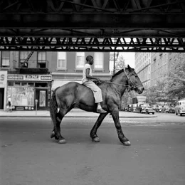 Ein Vivian Maier-Foto: Ein Afroamerikaner reitet auf einem Pferd durch die Stra&szlig;en New York Citys.