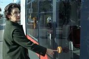 Regine Beranek (Hertha Schell) bei der Straßenbahnhaltestelle.
