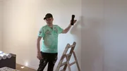 Tino und Carsten (Foto) arbeiten daran, die Wohnung von Jasmin und Maik neu zu tapezieren und zu streichen.