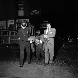 Ein Vivian Maier-Foto: Ein Mann wird von Polizisten &uuml;ber die Stra&szlig;e geschleift.
