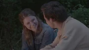 A boy and girl sitting around a campfire.