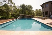 The completed pool in the backyard with a jacuzzi and waterfall.