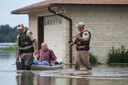 Chris and Benny rescue a man from his flooded home.