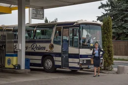Irma (Lisa Wagner) wartet, dass die Reisegruppe die Pause an der Tankstelle beendet und sie weiterfahren k&ouml;nnen.