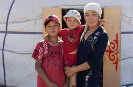 Mutter G&uuml;lnas mit ihren S&ouml;hnen vor dem Sommerheim, ihrer Jurte