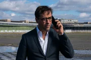 Joachim Vernau (Jan Josef Liefers) spricht mit Hartmann am Telefon.