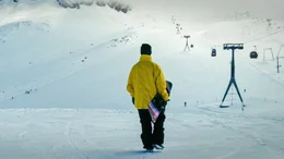 Snowboardfahrer bei der Skipiste vor der Abfahrt.