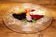 Die Nachspeise: Topfennocken auf Johannisbeerkompott und Stracciatella-Parfait.
