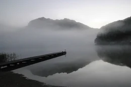 Altausseer See mit Bootsteg im Herbstfr&uuml;hnebel und Blick auf Tisselwand.
