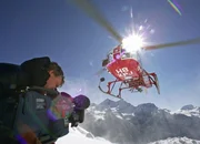 Kameramann Andreas Baumberger mit Kamera und ein Helikopter der Air Zermatt im Anflug.
