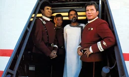 Der vulkanische Herrscher Sybok (Laurence Luckinbill, 2.v.r.) hat die Enterprise mit Captain Kirk (William Shatner, r.), Dr. McCoy (DeForest Kelley, 2.v.l.), Mr. Spock (Leonard Nimoy, l.) und der ganzen Crew gekapert, um einen Planeten anzufliegen, auf dem Gott wohnen soll ...