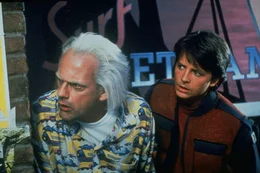 Doc Brown (Christopher Lloyd, l.) reist mit Marty (Michael J. Fox) ins Jahr 2015, wo Marty einen Zwischenfall verhindern soll, der seine zuk&uuml;nftige Familie ruinieren w&uuml;rde.