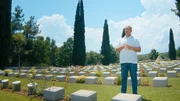 Ein Mann steht auf einem Friedhof