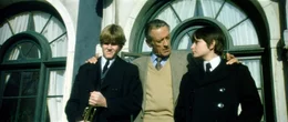 Der Firmenboss Richard Thorn (William Holden, M.) verabschiedet seinen Sohn Mark (Lucas Donat, l.) und seinen Neffen Damien (Jonathan Scott-Taylor, r.), f&uuml;r die nun der Ernst des Lebens auf der Milit&auml;rschule beginnt ...