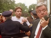 Detective Thomson (Wayne Tippit) hindert den FBI-Agenten Mulder (David Duchovny) mit Gewalt daran, sich in die Mordermittlungen wegen des Jersey-Teufels einzuschalten. Detective Thomson (Wayne Tippit) hindert den FBI-Agenten Mulder (David Duchovny) mit Gewalt daran, sich in die Mordermittlungen wegen des Jersey-Teufels einzuschalten.