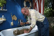 Nat&uuml;rlich braucht der herrenlose Hund ein Bad, meint Peter (Peter Lustig). Der Hund ist jedoch anderer Meinung.