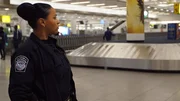 Officer Brito stands by the baggage claim area. (National Geographic/Lucky 8 TV)