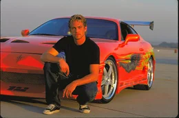 Brian O'Conner (Paul Walker) vor seinem roten Sportwagen.