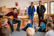 Dominik Morgenstern (Joscha Kiefer, r.) und Toni Bischoff (Amanda da Gloria, M.) beobachten den Singkreis von Florian Buchner (Pablo Sprungala, l.) und den Kindern in der Kita. Dominik Morgenstern (Joscha Kiefer, r.) und Toni Bischoff (Amanda da Gloria, M.) beobachten den Singkreis von Florian Buchner (Pablo Sprungala, l.) und den Kindern in der Kita.