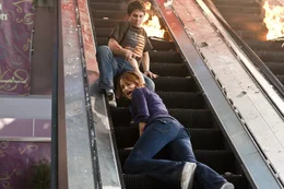 Verzweifelt versucht Nick (Bobby Campo, hinten) seine Freundin Lori (Shantel VanSanten, vorne) aus dem zerst&ouml;rten Kino zu retten. Doch dann brechen Teile der Rolltreppe ab, w&auml;hrend der Treppenmotor stur weiterl&auml;uft ...