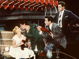 Dr. Otto Dernburg (Heinz R&uuml;hmann) alias Charleys Tante ist drauf und dran, aus der Rolle zu kippen. Sein Bruder Ralf (Claud Biederstaedt, 2. v. re.) hat seine liebe Not, ihn davon abzuhalten, dass er sich allzu liebevoll um Ralfs Angebetete Britta (Ina Peters) bem&uuml;ht. Ralfs Freund Charley Sallmann (Walter Giller) fragt sich verzweifelt, was seiner tollen "Tante" noch alles einfallen wird.