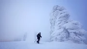 Im Winter pfeift ein eisiger Wind um die Felsen von Manpupunjor im Ural. Colin Devey findet Schutz im Windschatten der gigantischen S&auml;ulen.