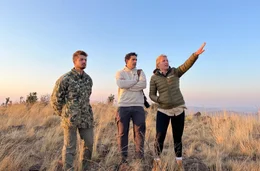 Marios Michaelidis (M.) und Lea Henzgen (r.) von der AMES-Foundation mit Security-Chief Tyler Michael (l.) auf dem Sonop-Berg. Sie blicken auf das Dabchick Wildlife Reservat sowie angrenzende L&auml;ndereien. Ihr Plan: Durch Biodiversity Credits wollen sie Geld einnehmen, um das Reservat zu vergr&ouml;&szlig;ern.