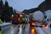 Ein mit Chemikalien beladener Tankwagen steckt auf einer Straße mit vielen vorbeifahrenden Autos im Graben fest.